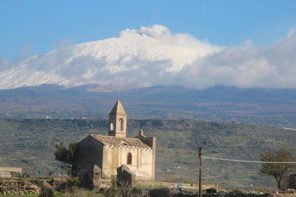 Una chiesetta di campagna con l’Etna innevato sullo sfondo