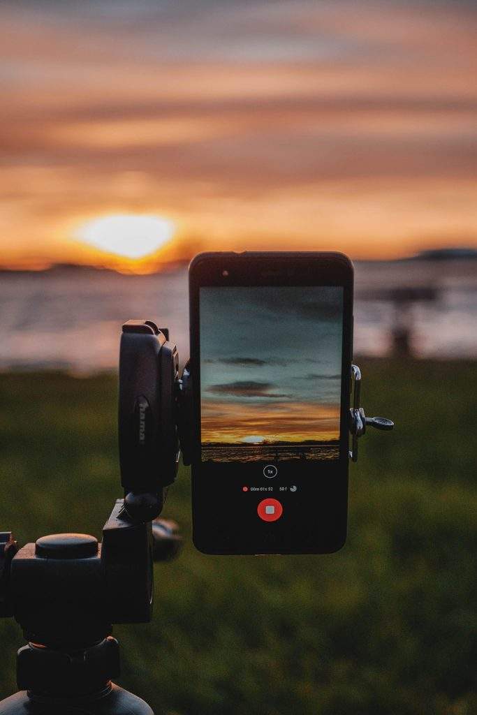Smartphone su treppiede che riprende un tramonto